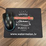 Peles paliktnis ar apdruku Watermelon merch uz biroja galda ar datorpeli.